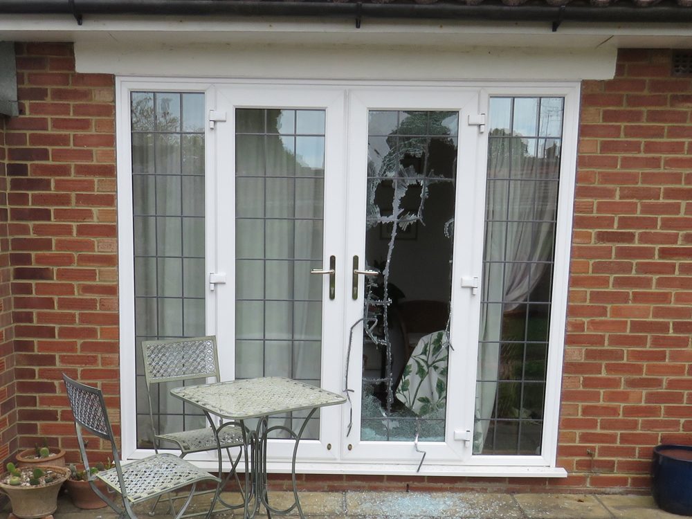 A smashed patio door after a break-in, before it is secured