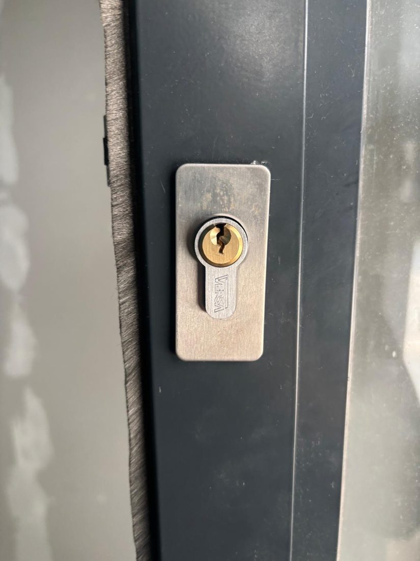 A euro cylinder fitted to a dark grey aluminium shopfront door
