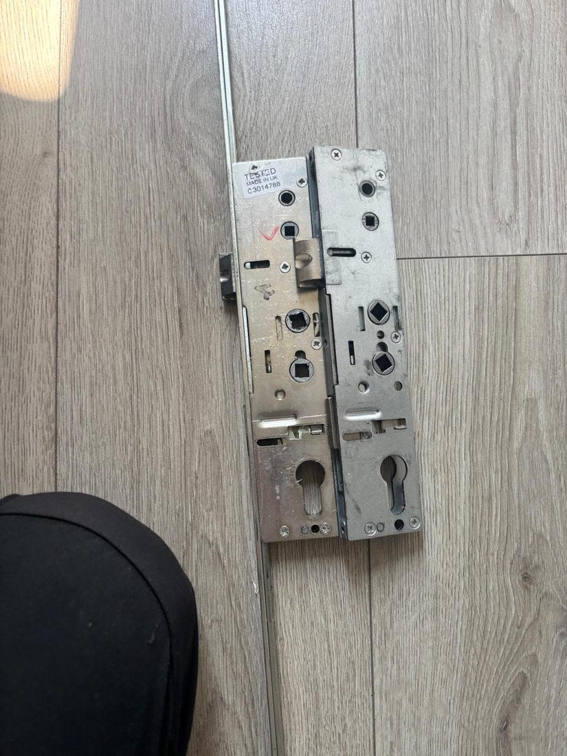 A worn uPVC door gearbox laid beside the new replacement centre case that went in