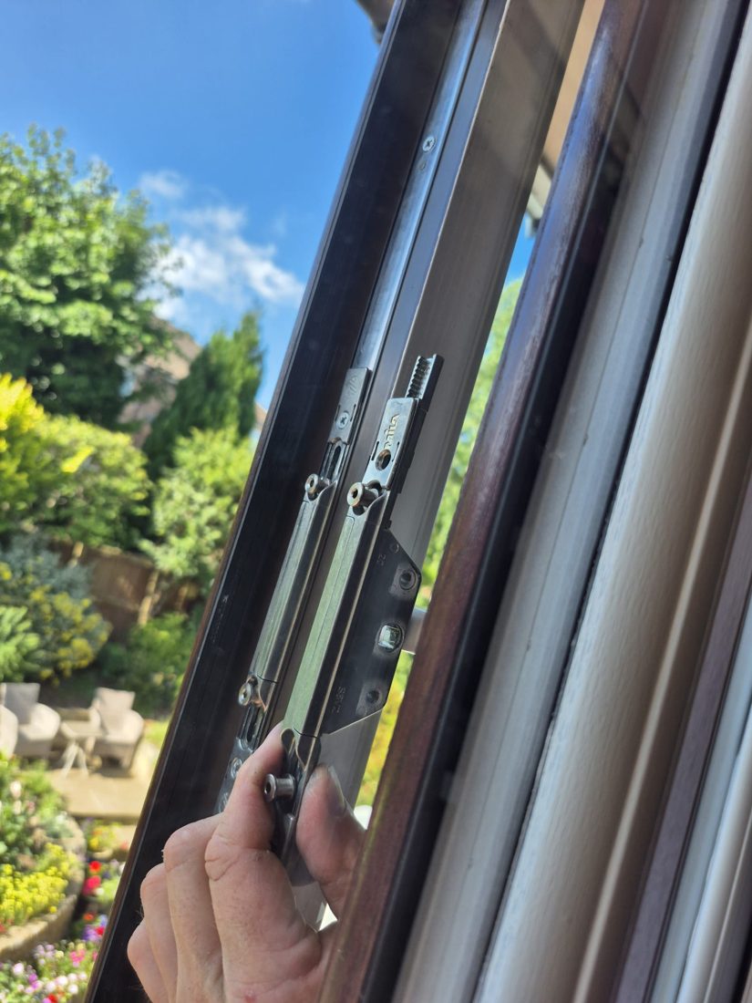 The espagnolette locking strip exposed down the edge of a uPVC window during a mechanism repair
