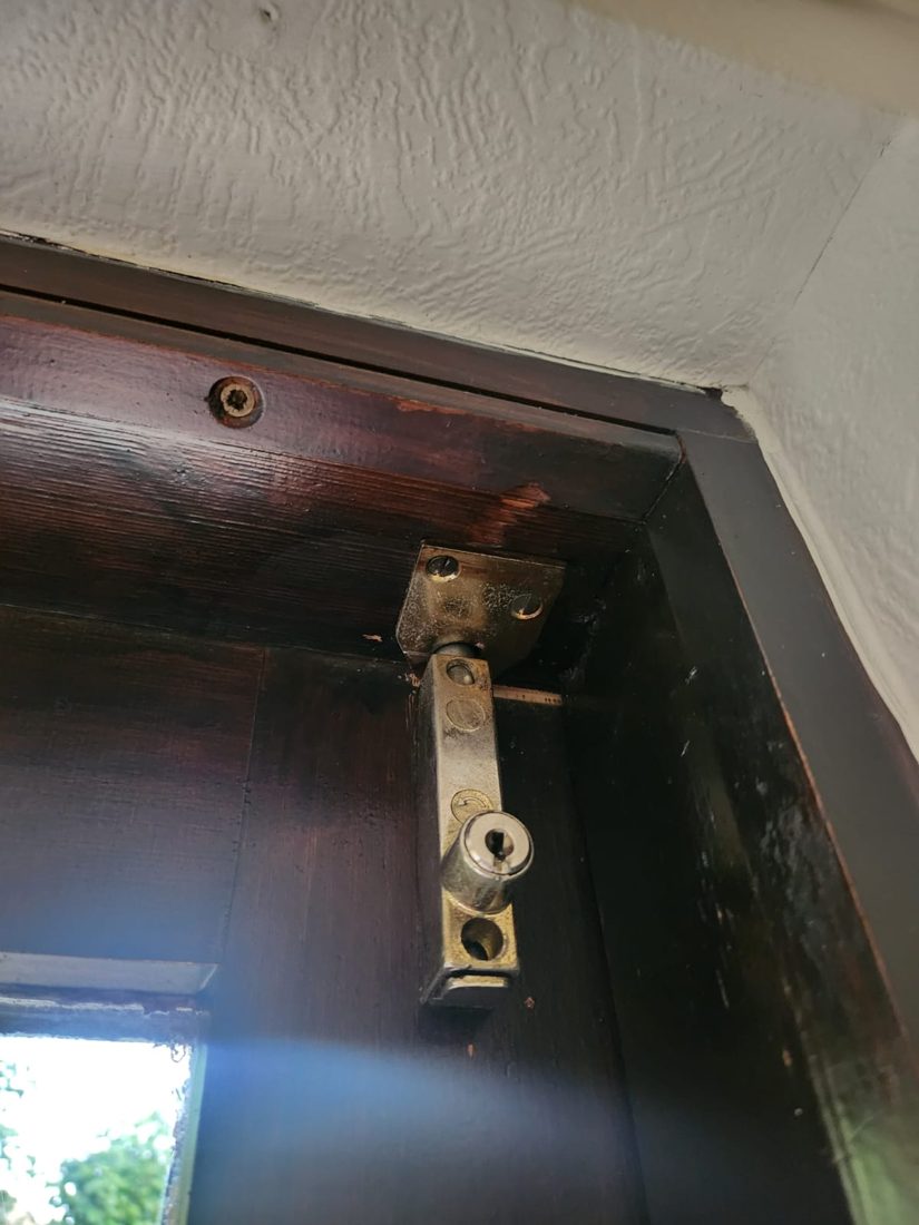 A shootbolt mechanism replaced on the edge of a timber sliding patio door