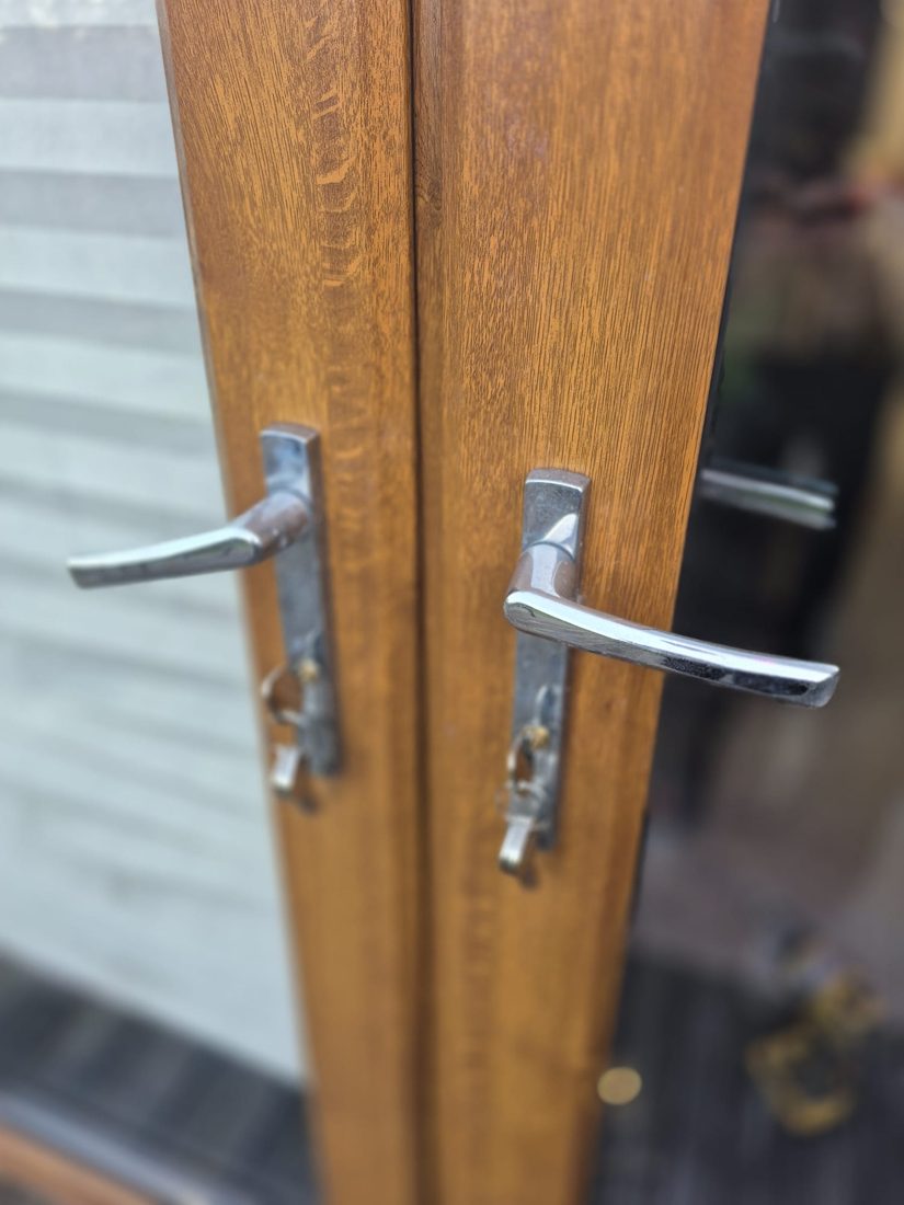 Chrome lever handles on a timber French door after a cylinder change