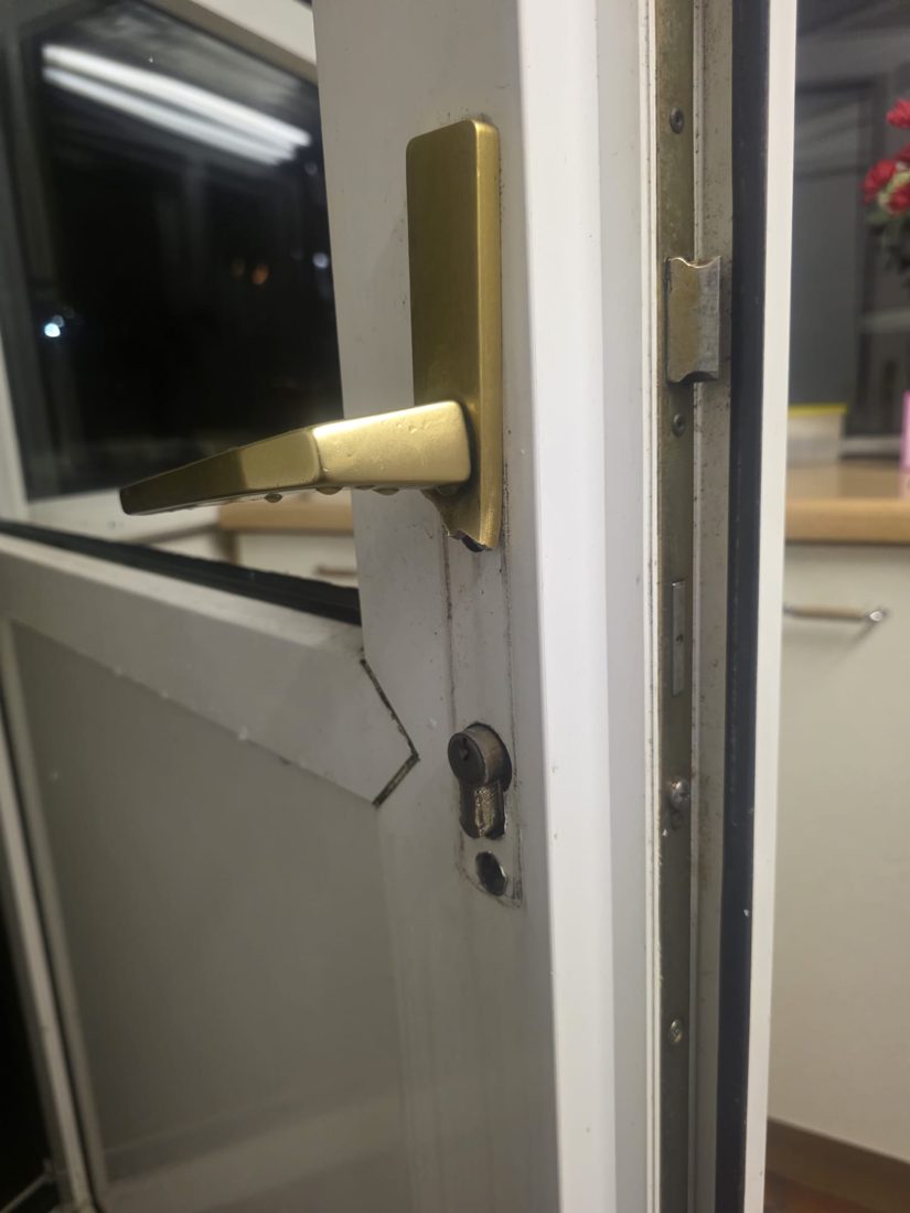 A damaged uPVC door being secured at night with a new anti-snap cylinder after a break-in