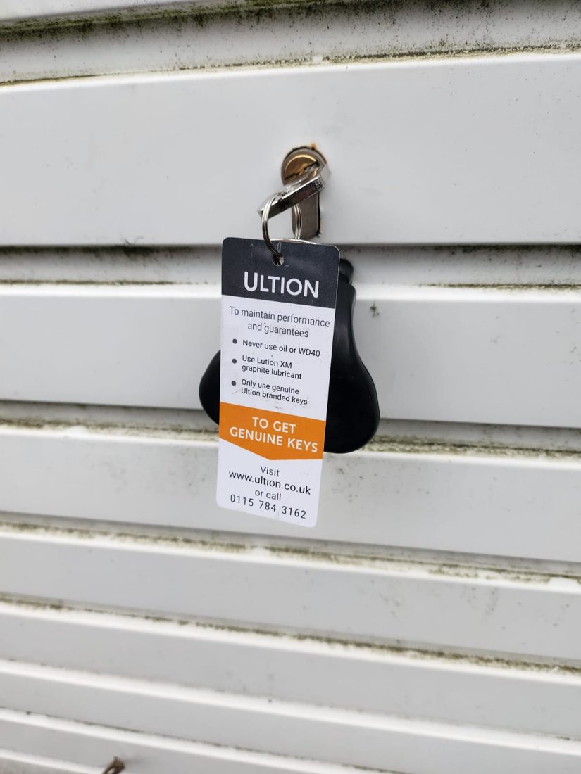 A high-security Ultion anti-snap cylinder fitted to a roller-shutter garage door