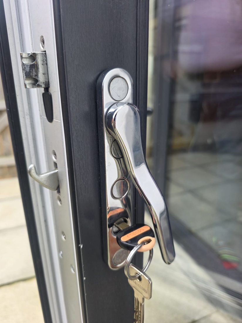 A new handle and keys on an anthracite bifold door, showing the folding leaves