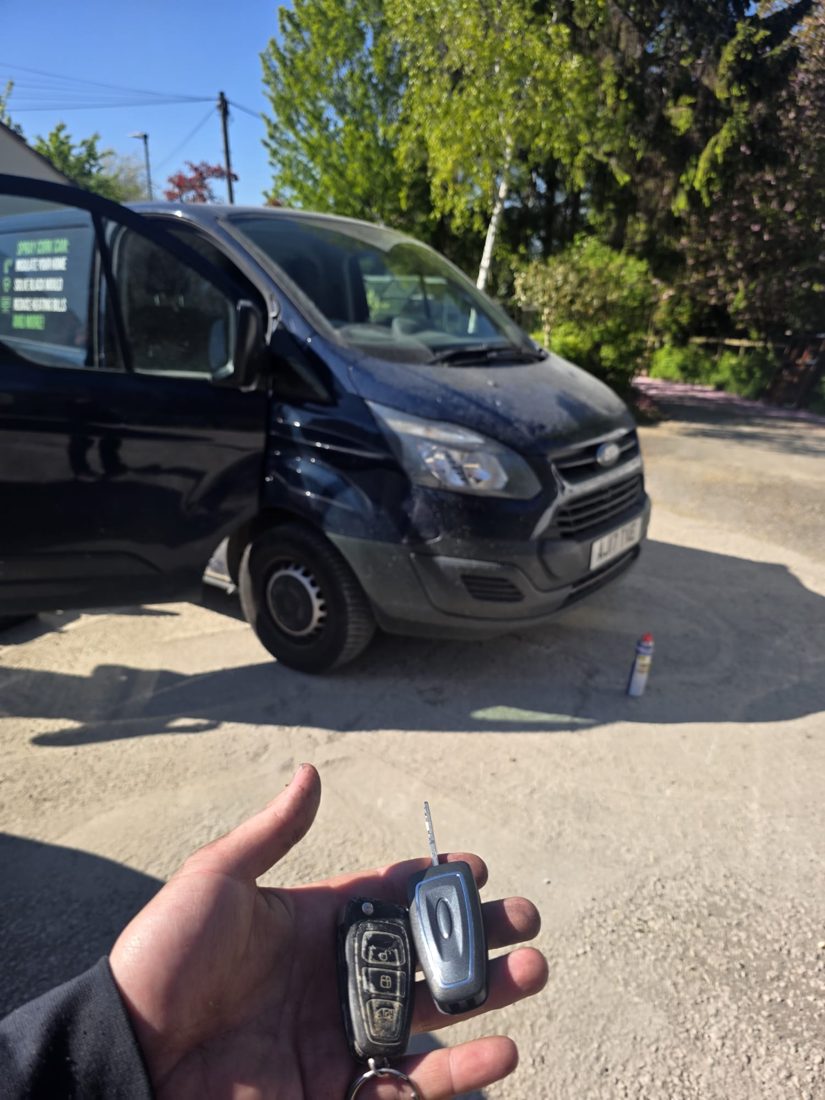 A Ford Transit van key and spare blade held in front of the van after programming