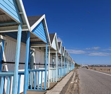 A row of pastel beach huts along Bridlington's seafront promenade, a classic feature of the traditional Yorkshire seaside resort