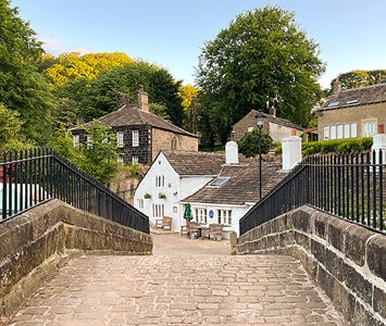 The old packhorse bridge over the River Ryburn at Ripponden, leading to the white-painted Old Bridge Inn and village cottages
