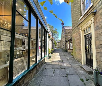 A flagged shopping passage off Pateley Bridge's steep High Street, lined with the independent shops the town is known for