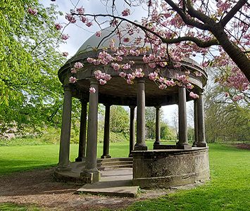 The domed well-head at Tewit Well on the Stray, marking the spot where Harrogate's first mineral spring was discovered, ringed by spring blossom
