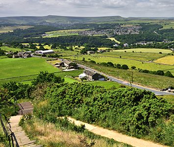 Looking out from Castle Hill across the fields and rooftops of the Huddersfield district, with the high moors rising in the distance