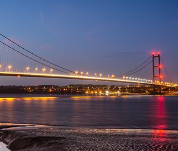 The Humber Bridge lit up at night, the Grade I listed single-span suspension bridge that has spanned the Humber estuary by Hull since 1981 — for years the longest of its kind in the world