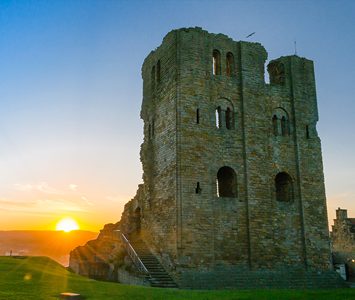The ruined keep of Scarborough Castle at sunset, the medieval fortress on the headland above the town — a short drive away