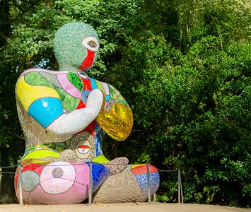 A brightly coloured mosaic sculpture among the trees at the Yorkshire Sculpture Park in the Bretton estate near Wakefield